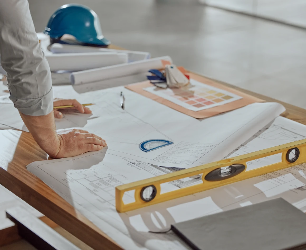 Engineer analyzing blueprints and using level
